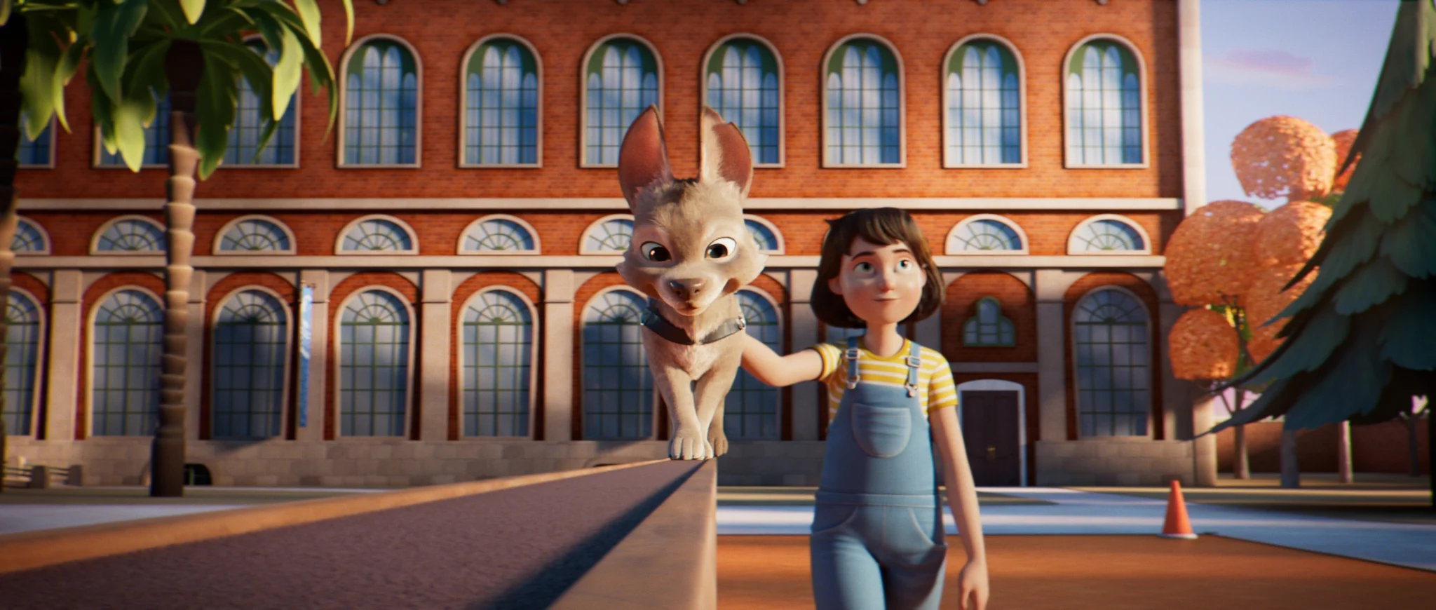 A girl in a yellow striped T-shirt strokes a big-eared puppy walking along the top of a wall.